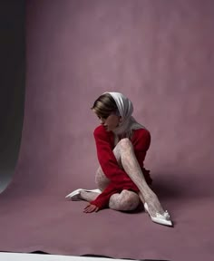 a woman is sitting on the ground with her legs crossed and wearing white stockings,