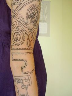 a woman with a tattoo on her arm that has an image of a car in it