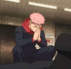 a man with pink hair sitting on top of a bed