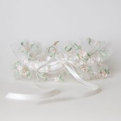 Feminine & fancy-free!Free to be you, just as you are. Our 'Wild Child' style wedding garter heirloom is the perfect wedding heirloom for brides who are inspired by a carefree, effortless, natural bridal style that comes from the purest place of love. Details Production Shipping Sizing Main Garter: Ivory satin background with an overlay of a layer of blush and sage embroidered floral tulle with an ivory satin bow tied in the center with long tails (approximately 2 inches wide).Matching Tossing G Garter Belts Bridal, Boho Wedding Garter, Boho Style Bride, Satin Background, Bride Garter, Sage Wedding, Heirloom Wedding, Wedding Garters, Wedding Kiss