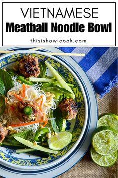 vietnamese meatball noodle bowl on a blue and white plate with limes next to it