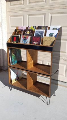 a book stand with several books on it in front of a garage door that is open