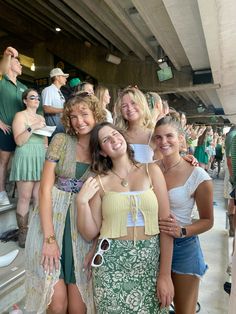 four girls are standing together in front of a crowd