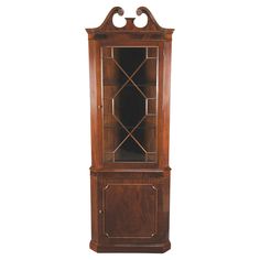 a tall wooden cabinet with glass doors on the front and bottom shelves, inlaid with metal details