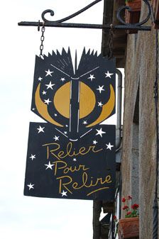 a sign hanging from the side of a building that says relax and relive