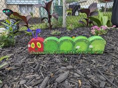 the very hungry caterpillar is made out of grass and plastic straws on top of mulch