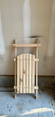 a chair made out of wooden planks sitting in a room next to a wall