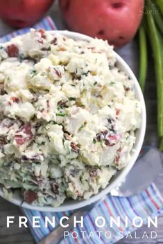 a white bowl filled with potato salad next to green beans and two red apples in the background