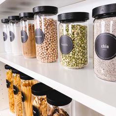 several jars filled with different types of food on top of a white shelf in a store