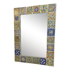 a mirror that is sitting on top of a white surface with colorful tiles in it