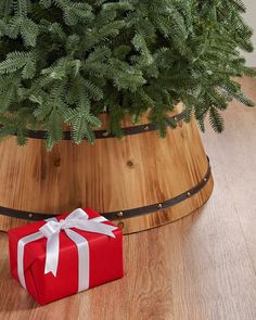 a red present box sitting on top of a wooden table next to a potted plant