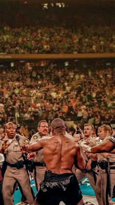 a group of men standing next to each other in front of a crowd