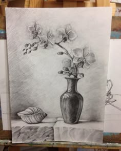 a drawing of flowers in a vase next to a seashell on a easel