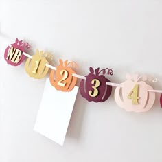 a paper sign that says happy birthday hanging from a line with cut out pumpkins