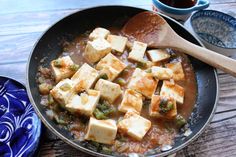 tofu and broccoli are being cooked in a pan