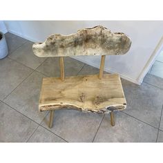 a wooden bench sitting on top of a tile floor next to a potted plant