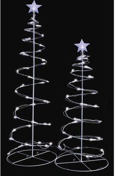 two white christmas trees with stars on top and lights in the shape of spirals