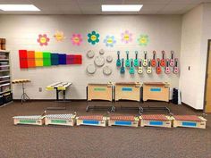 an empty room with several musical instruments on the wall and colorful flowers painted on the wall