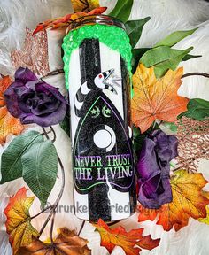 a can of liquid sitting on top of some leaves and other fall foliage, with the caption never trust the living