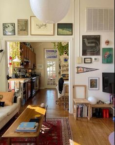 a living room filled with furniture and lots of pictures on the wall above it's doorway