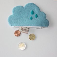 there is a coin purse that has a cloud on it and some coins in front of it