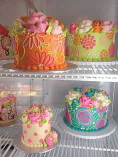 there are three cakes on the shelves in the refrigerators, each decorated with different designs