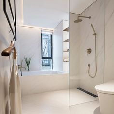 a bathroom with a white toilet sitting next to a bath tub and shower head mounted on the wall