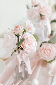 pink flowers are in vases on the table