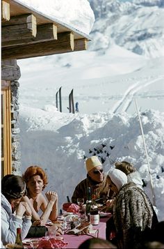 people sitting at a table outside in the snow