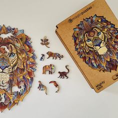 a wooden puzzle with an image of a lion and other animal pieces on it next to a notebook