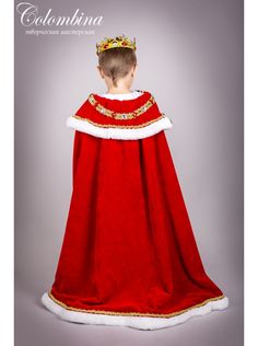 a little boy dressed in a red and white costume with a crown on his head