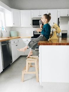 a young boy sitting on top of a kitchen counter