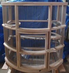 a large bird cage sitting on top of a wooden table