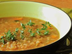 a white bowl filled with soup and garnished with parsley on the side