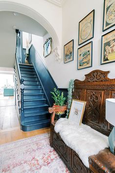 an ornately decorated entryway with blue stairs and pictures on the wall above it