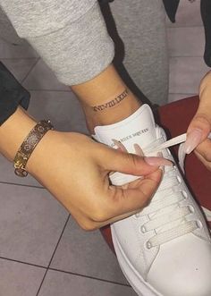 a person tying a pair of white sneakers