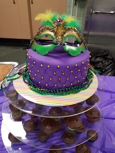 there is a cake that has a mardi gras mask on top of it