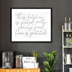 there is a framed quote on the wall next to a potted plant and coffee maker