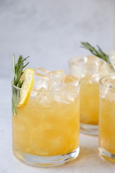 three glasses filled with lemonade and rosemary garnish