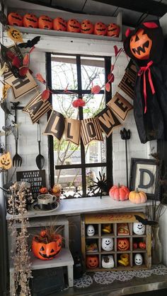 halloween decorations are displayed on the windowsill in this home decorated with pumpkins and jack - o'- lanterns