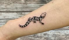 a small lizard tattoo on the leg