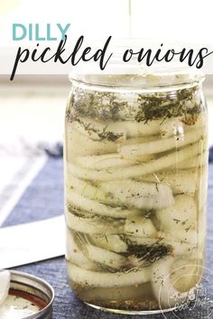 a jar filled with pickled onions sitting on top of a blue cloth covered table