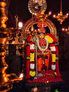 an idol is displayed in front of candles