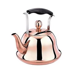 a tea kettle with a black handle and a rose gold finish on the top,