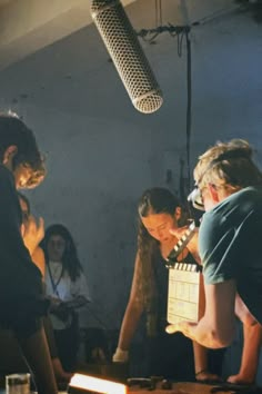 a group of people standing around a table with a microphone on top of it next to each other