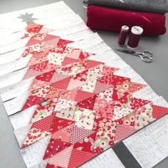 the quilts are laid out on the table ready to be sewn together with scissors and thread