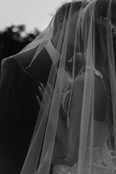 a bride and groom kissing under the veil