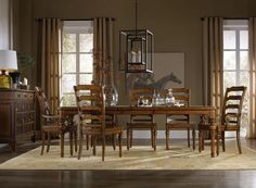 a dinning room table with chairs and a horse statue in the window behind it