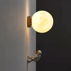 an astronaut is hanging from the side of a wall with a lamp on it's head