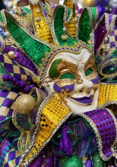 a mardi gras mask is adorned with beads